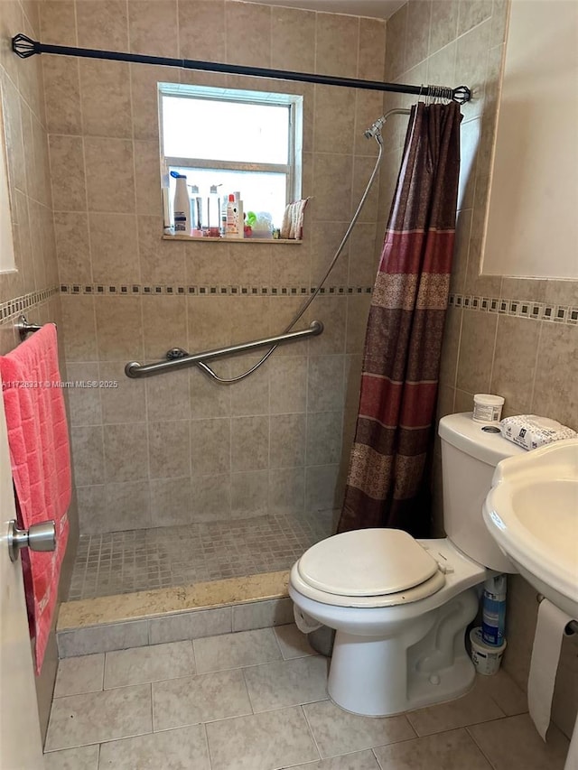 bathroom featuring tile walls, toilet, walk in shower, and tile patterned flooring