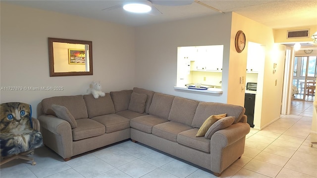 tiled living room featuring ceiling fan