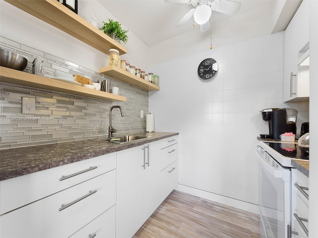 kitchen with sink, white cabinets, tasteful backsplash, and electric stove