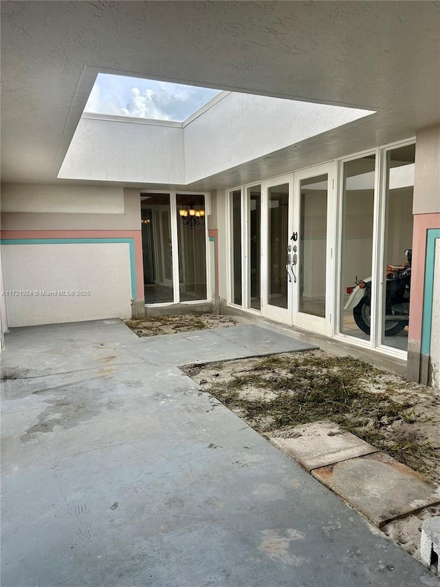 interior space with a skylight, french doors, and concrete flooring