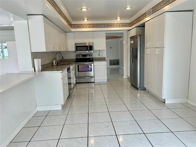 kitchen with white cabinets, appliances with stainless steel finishes, and crown molding