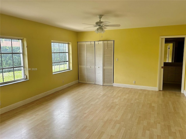 unfurnished bedroom with light wood-type flooring, ceiling fan, a closet, and multiple windows