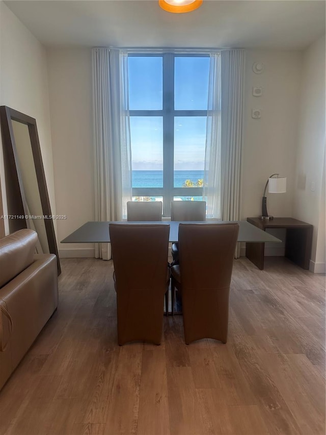 dining area featuring a water view and hardwood / wood-style flooring