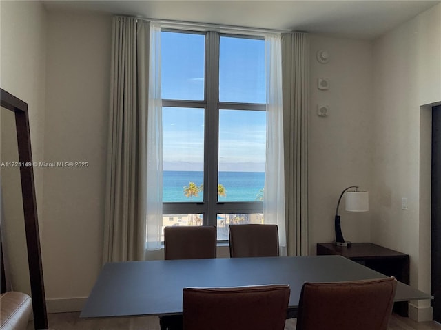 dining space featuring a water view and hardwood / wood-style flooring