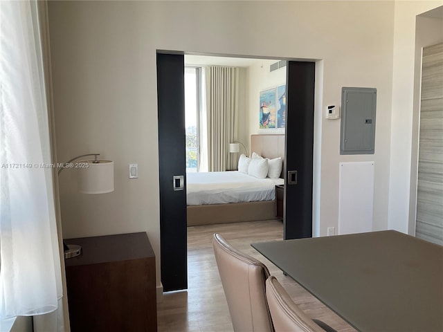 bedroom featuring light hardwood / wood-style floors and electric panel