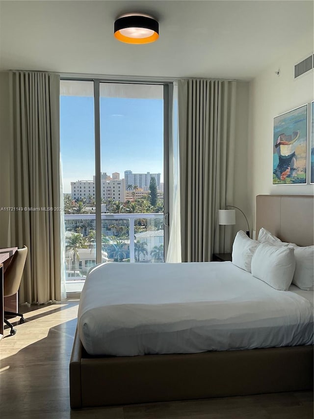 bedroom featuring floor to ceiling windows and hardwood / wood-style flooring