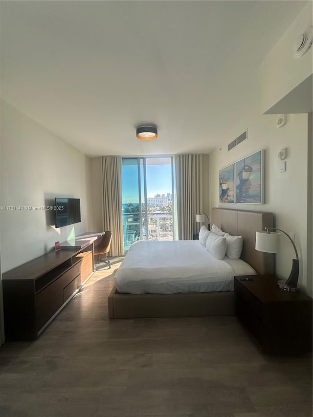 bedroom featuring hardwood / wood-style floors and expansive windows