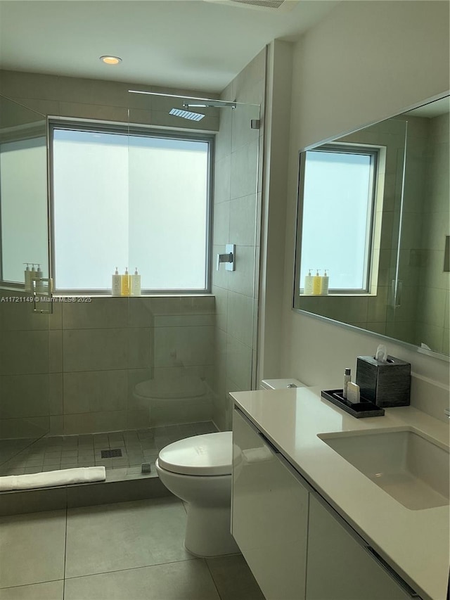 bathroom with plenty of natural light, tile patterned floors, vanity, and toilet