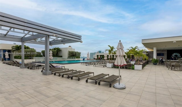 view of patio / terrace featuring a community pool and a pergola