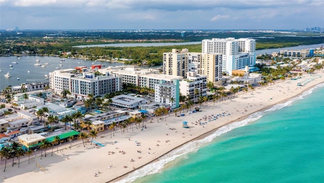 birds eye view of property featuring a beach view and a water view