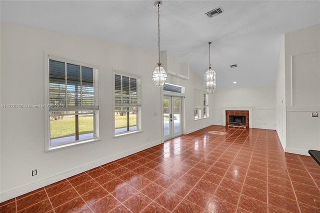 unfurnished living room featuring french doors, vaulted ceiling, and tile patterned floors