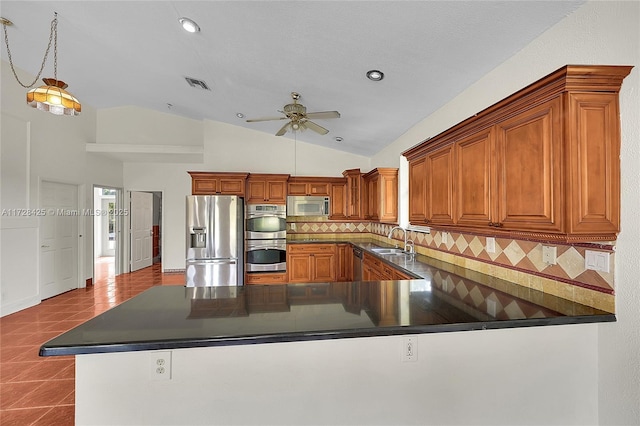 kitchen featuring backsplash, tile patterned flooring, kitchen peninsula, sink, and appliances with stainless steel finishes