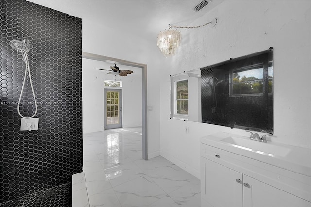 bathroom with vanity, a shower, and ceiling fan with notable chandelier