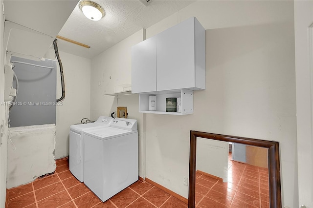 clothes washing area featuring cabinets, a textured ceiling, washer and clothes dryer, and tile patterned flooring