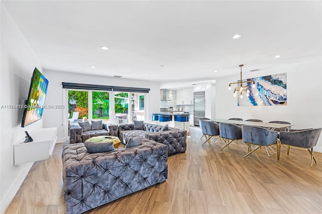 living room featuring light hardwood / wood-style flooring and an inviting chandelier