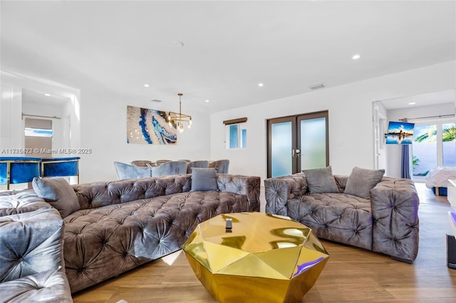 living room featuring french doors and an inviting chandelier