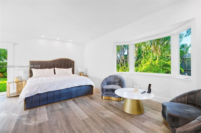 bedroom with multiple windows and light hardwood / wood-style flooring