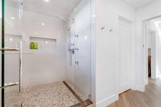 bathroom featuring hardwood / wood-style floors and a shower with door