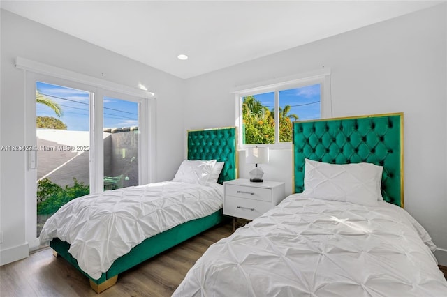 bedroom with access to exterior and dark wood-type flooring