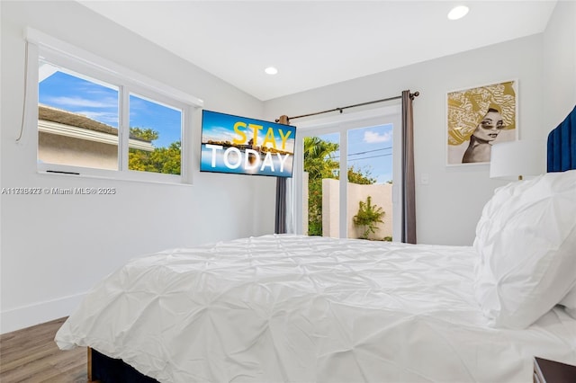 bedroom with multiple windows and hardwood / wood-style floors