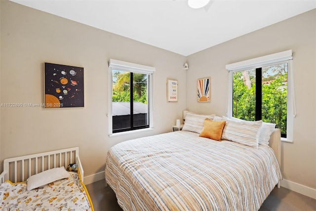 bedroom with dark wood-type flooring and multiple windows