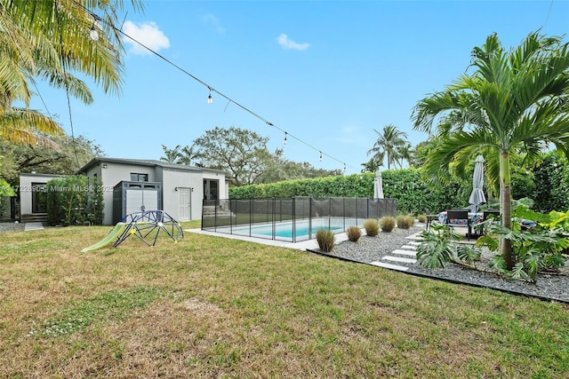 view of yard with a storage unit and a fenced in pool