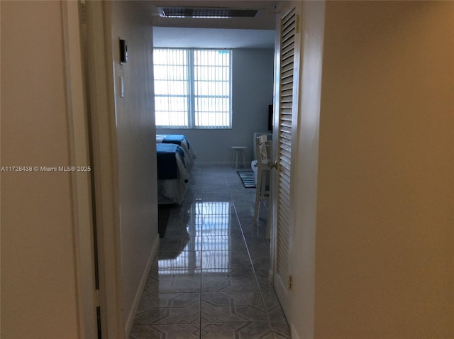 hall with dark tile patterned flooring