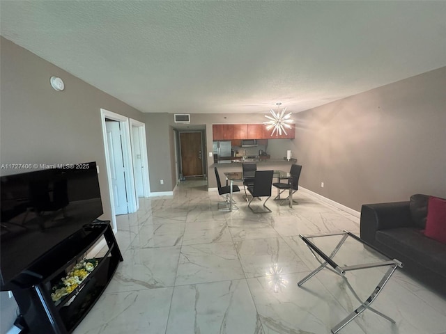 living room featuring a chandelier and a textured ceiling