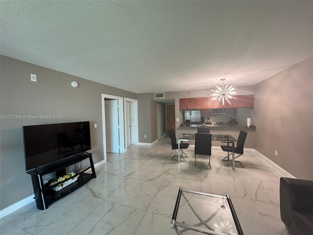 dining space featuring a textured ceiling, sink, and a notable chandelier