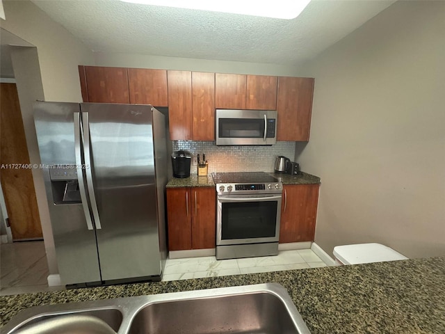 kitchen with a textured ceiling, appliances with stainless steel finishes, and tasteful backsplash