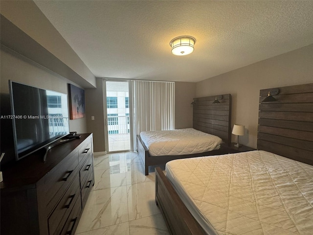 bedroom with access to exterior and a textured ceiling