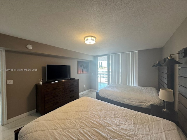 bedroom with access to exterior, a textured ceiling, and light tile patterned floors