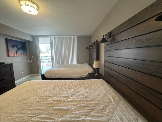 bedroom with access to outside and a textured ceiling