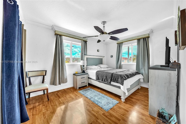 bedroom with ceiling fan, multiple windows, and light wood-type flooring