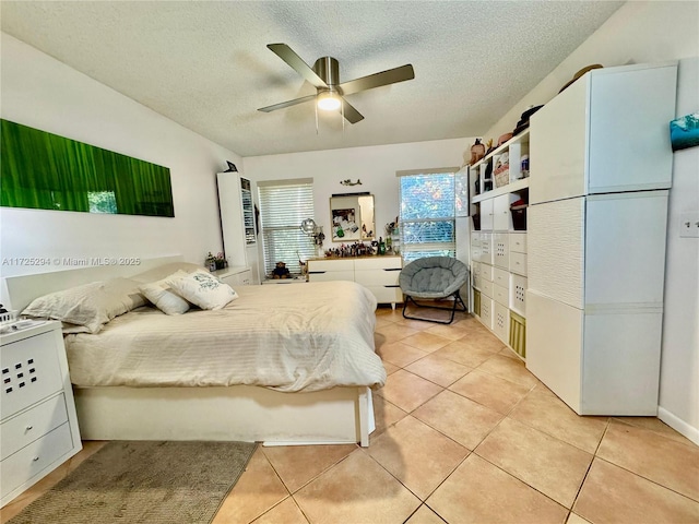 bedroom with ceiling fan, a textured ceiling, and light tile patterned flooring