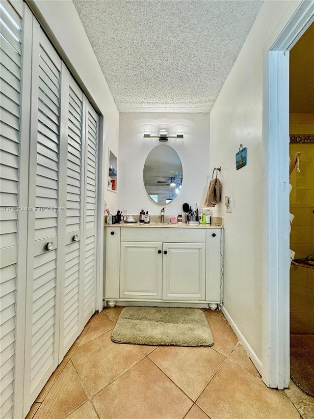 bathroom featuring a textured ceiling, tile patterned flooring, and vanity