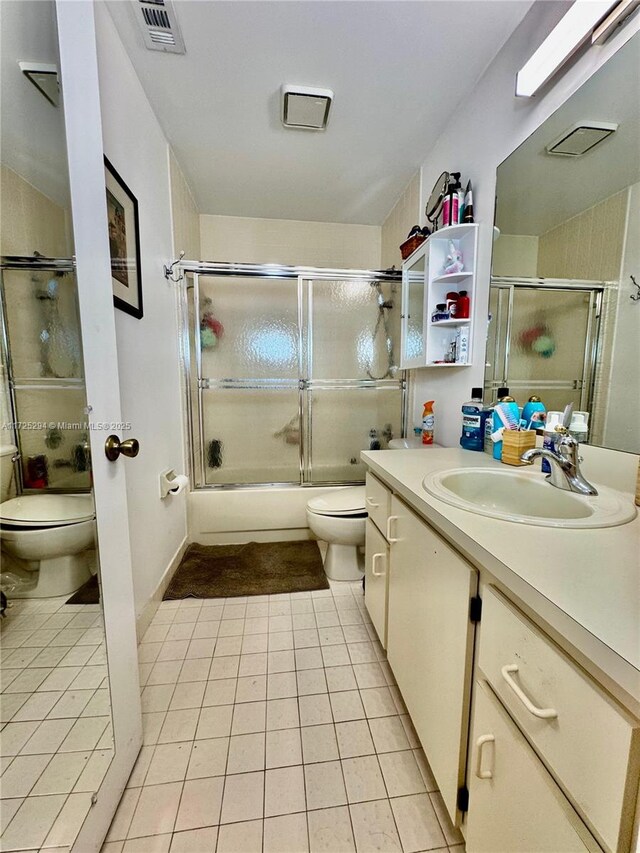 full bathroom with toilet, vanity, combined bath / shower with glass door, and tile patterned flooring