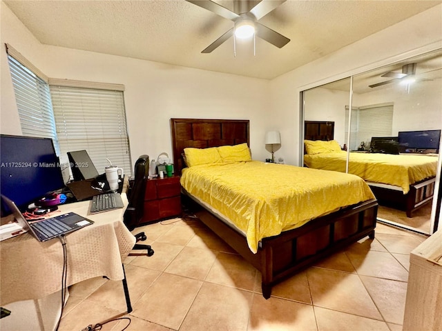 tiled bedroom featuring ceiling fan and a closet