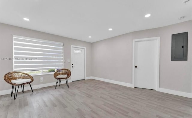 living area featuring electric panel and light hardwood / wood-style flooring