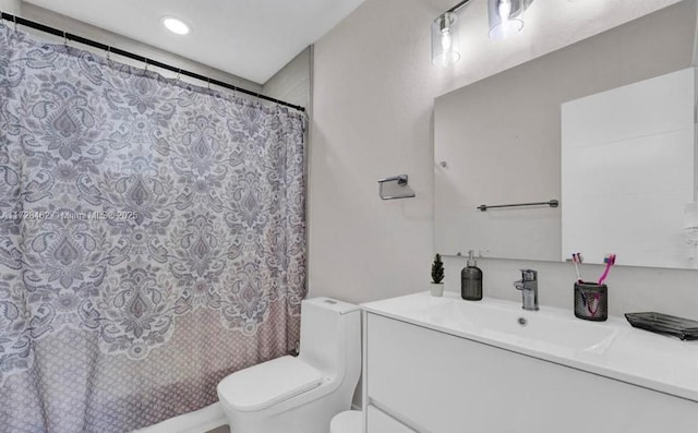 bathroom with toilet, walk in shower, and vanity