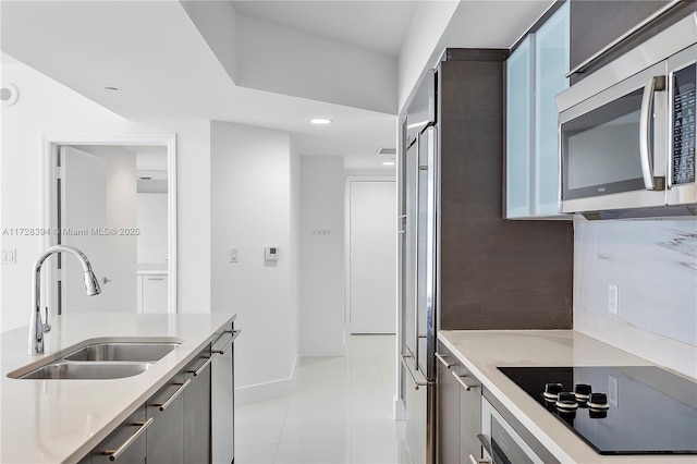 kitchen featuring light tile patterned flooring, stainless steel appliances, and sink