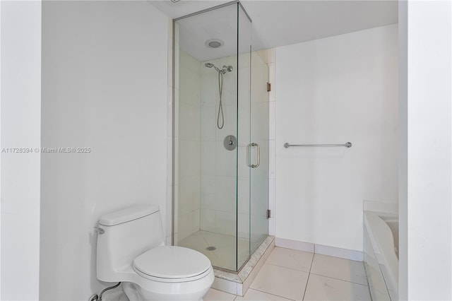 bathroom featuring tile patterned floors, toilet, and separate shower and tub