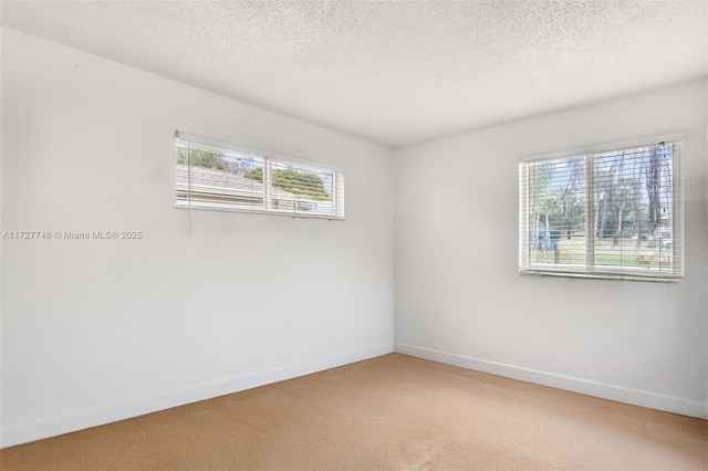 carpeted spare room with a textured ceiling