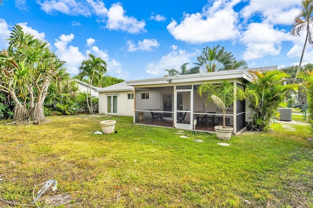 rear view of property with a lawn, central AC unit, and a sunroom