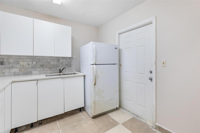 kitchen with sink, white cabinetry, white fridge, and tasteful backsplash