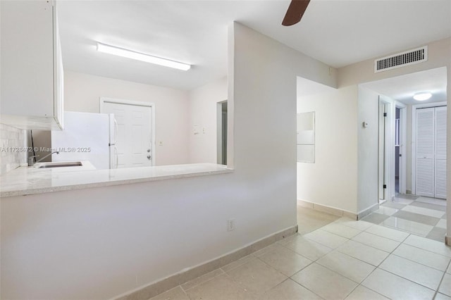 kitchen featuring white fridge, ceiling fan, and light tile patterned flooring