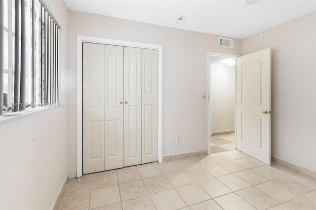 unfurnished bedroom with a closet and light tile patterned flooring