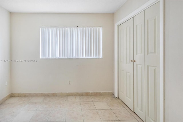 unfurnished bedroom with a closet and light tile patterned floors