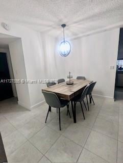 tiled dining room featuring a textured ceiling