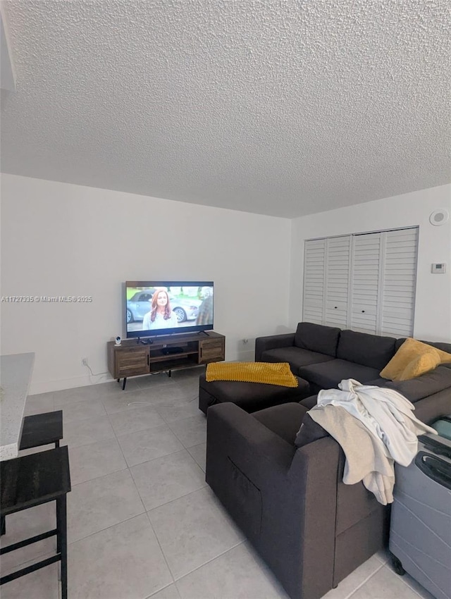 tiled living room featuring a textured ceiling